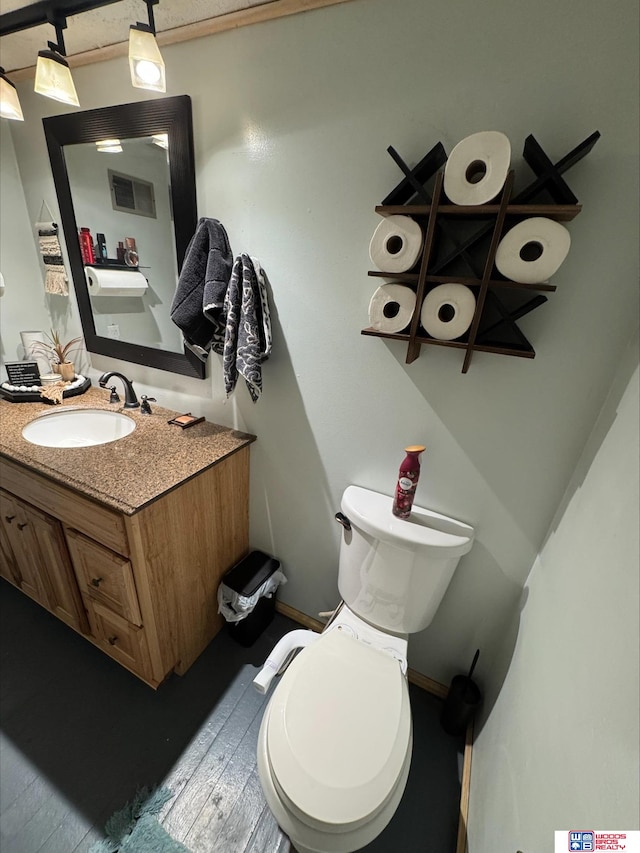 bathroom featuring vanity, wood-type flooring, and toilet