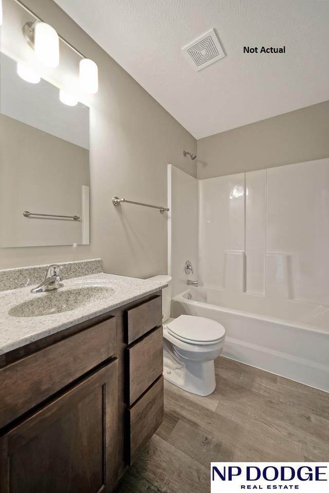 full bathroom with hardwood / wood-style flooring, vanity, toilet, and bathing tub / shower combination