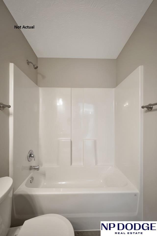 bathroom featuring a textured ceiling, shower / bathtub combination, and toilet