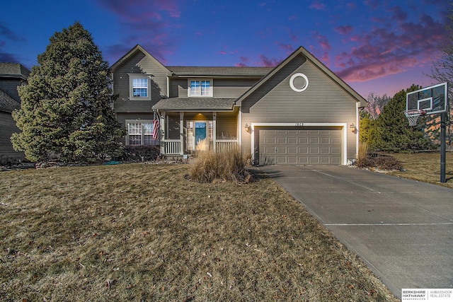 front of property with a porch, a garage, and a yard