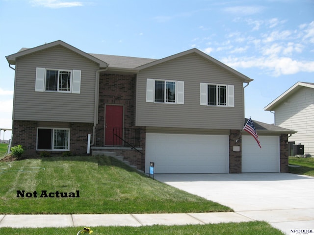 bi-level home featuring a garage and a front lawn