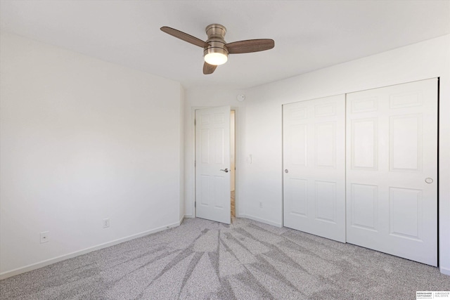 unfurnished bedroom featuring light carpet, ceiling fan, and a closet