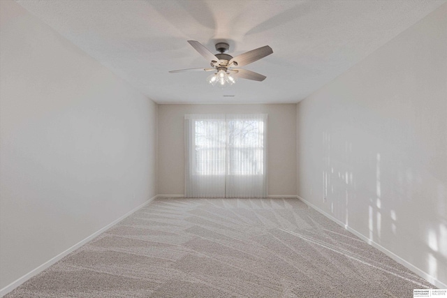 carpeted spare room with a textured ceiling and ceiling fan