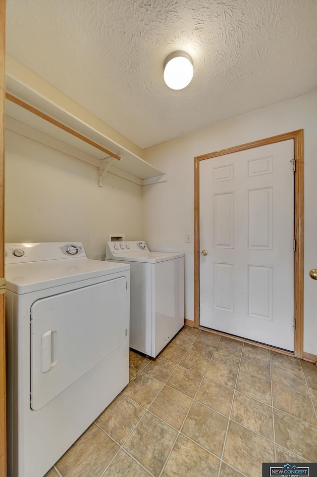 washroom featuring washer and dryer and a textured ceiling