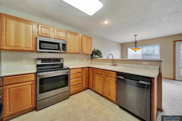 kitchen with sink, hanging light fixtures, kitchen peninsula, stainless steel appliances, and light carpet