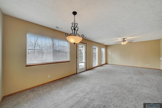 carpeted empty room featuring a textured ceiling and ceiling fan