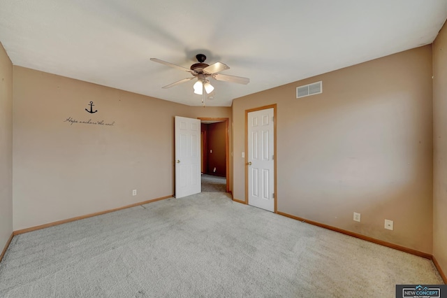 spare room featuring light colored carpet and ceiling fan