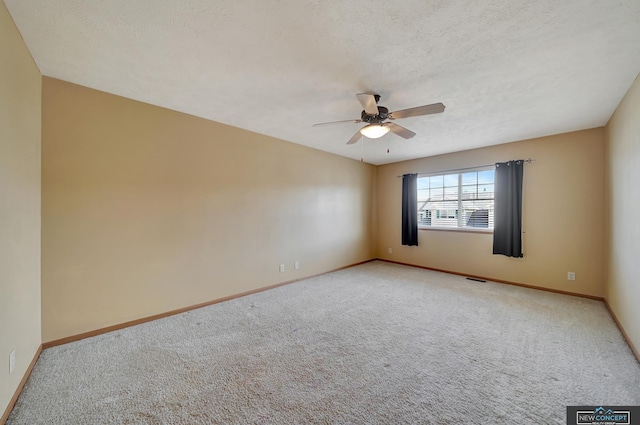 carpeted spare room with a textured ceiling and ceiling fan