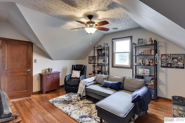 living room featuring vaulted ceiling, ceiling fan, and light hardwood / wood-style flooring