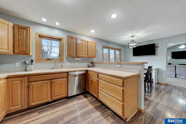 kitchen featuring hardwood / wood-style floors, decorative light fixtures, dishwasher, sink, and kitchen peninsula