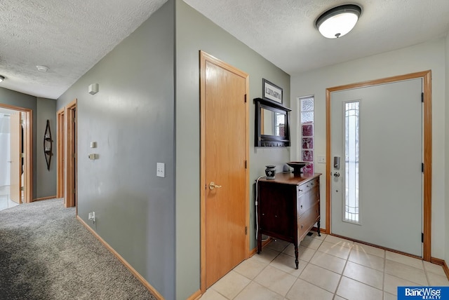 entryway featuring light tile patterned floors and a textured ceiling