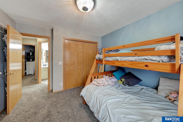 carpeted bedroom with a closet and a textured ceiling