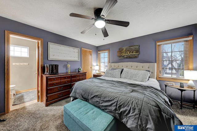 bedroom featuring multiple windows, ceiling fan, light carpet, and a textured ceiling