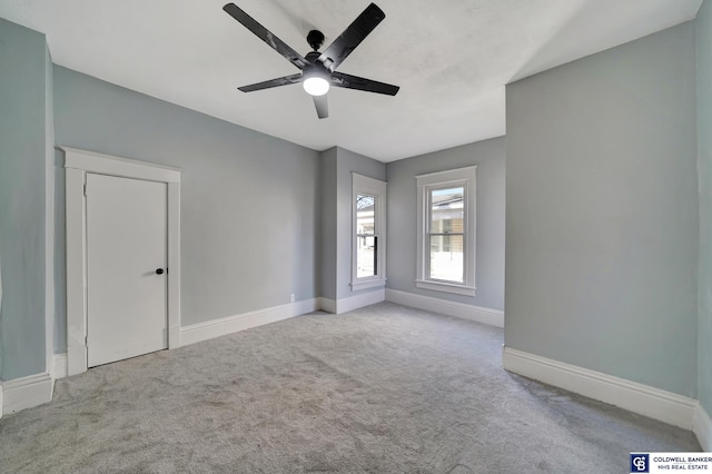 carpeted spare room featuring ceiling fan