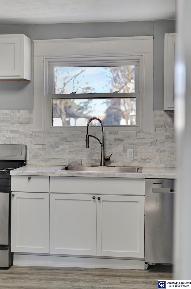 kitchen featuring sink, decorative backsplash, white cabinets, and appliances with stainless steel finishes