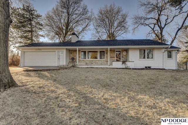 ranch-style home featuring a garage and a front lawn