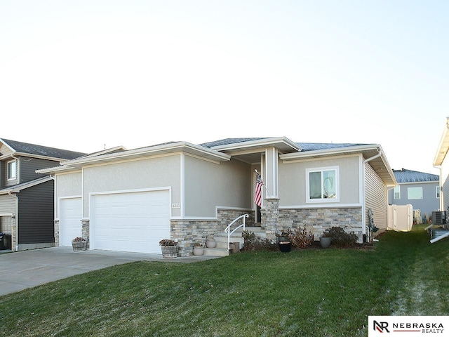 prairie-style home featuring a garage and a front lawn