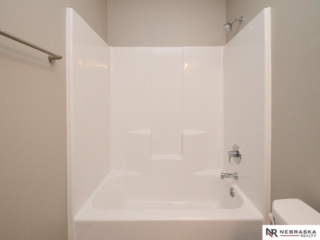 bathroom featuring tub / shower combination and toilet