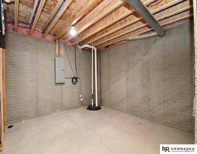 basement featuring brick wall and electric panel