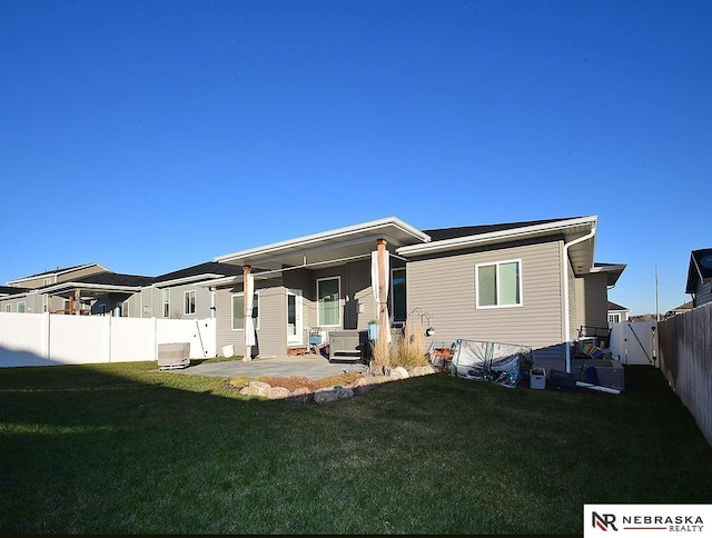 rear view of property with a lawn and a patio area