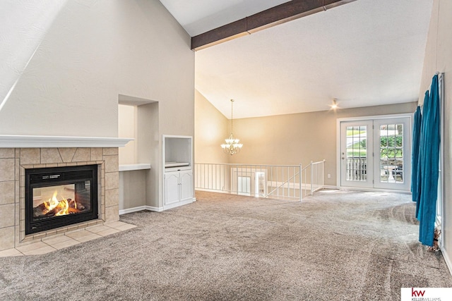 unfurnished living room with high vaulted ceiling, a tiled fireplace, light colored carpet, a notable chandelier, and beam ceiling