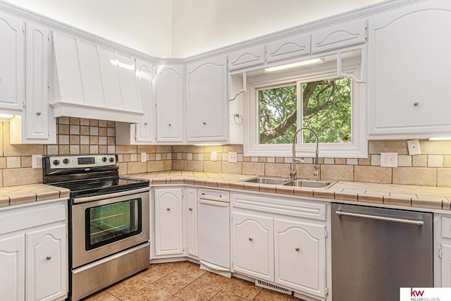 kitchen featuring tile counters, stainless steel appliances, and white cabinets