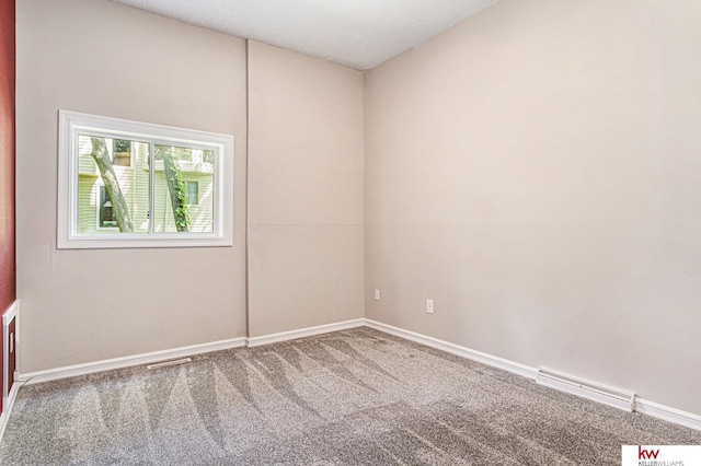 carpeted empty room featuring a textured ceiling