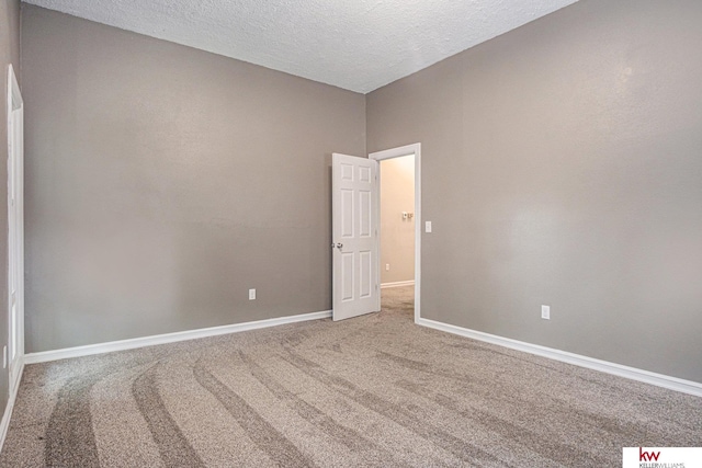 carpeted spare room with a textured ceiling