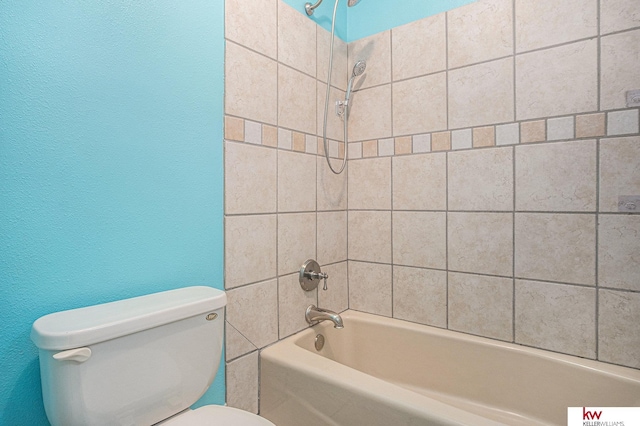 bathroom with tiled shower / bath and toilet