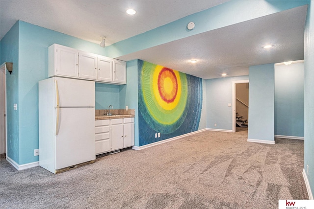 kitchen featuring white refrigerator, white cabinetry, sink, and light carpet