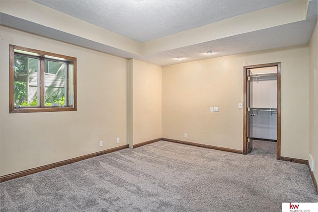 empty room with carpet and a textured ceiling