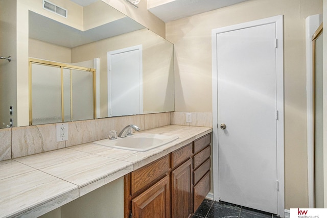 bathroom featuring vanity and a shower with door