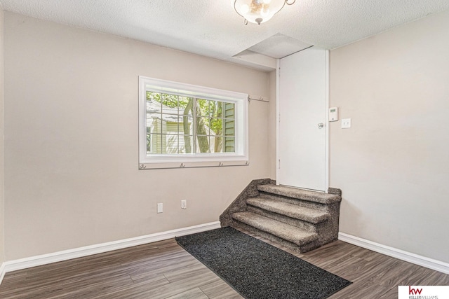 stairway featuring hardwood / wood-style floors and a textured ceiling