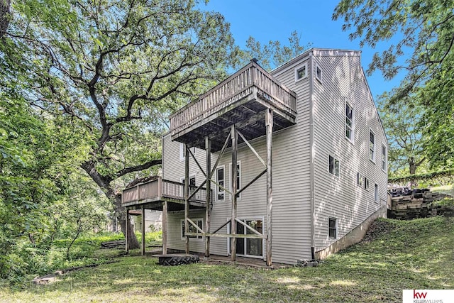 rear view of property with a yard and a deck