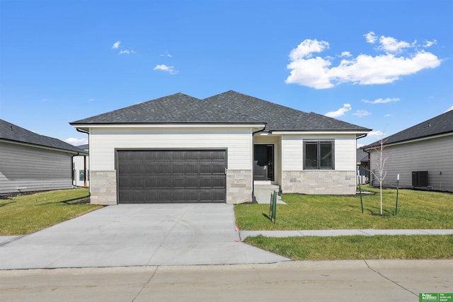 view of front of house with a garage, central AC, and a front lawn