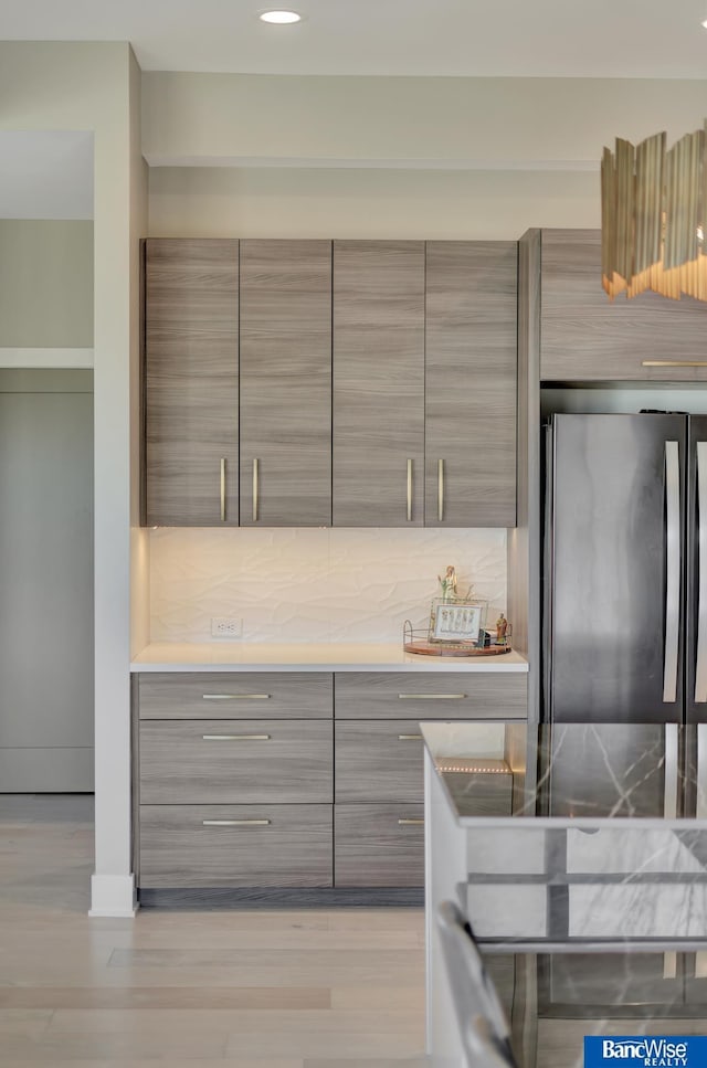 kitchen with decorative backsplash, stainless steel fridge, and gray cabinets