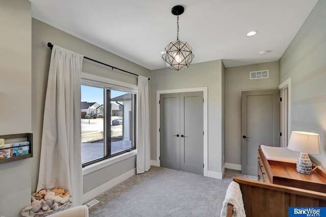 bedroom with light colored carpet, a notable chandelier, and a closet