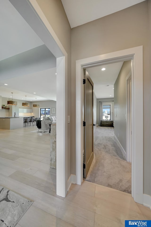 hallway with light carpet and plenty of natural light