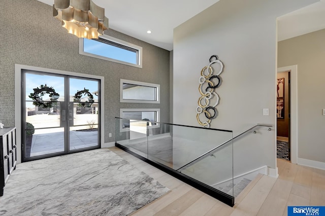 interior space featuring hardwood / wood-style flooring, a notable chandelier, and french doors