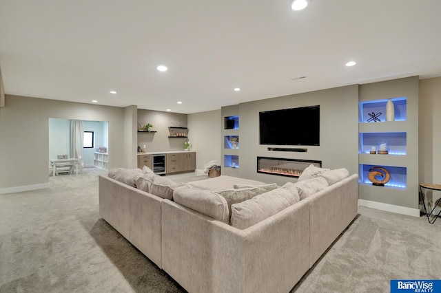 carpeted living room featuring built in shelves and beverage cooler