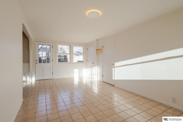 spare room with light tile patterned floors and crown molding