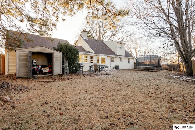 back of property featuring central AC unit, a patio, a shed, and a trampoline