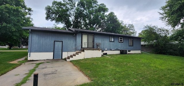 view of front of property with central AC and a front lawn