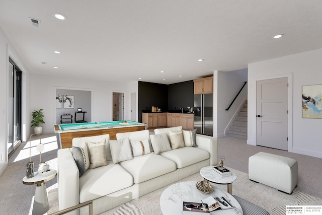 living room with pool table, sink, and light carpet