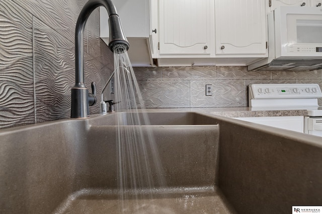 room details with white cabinetry, sink, and tasteful backsplash