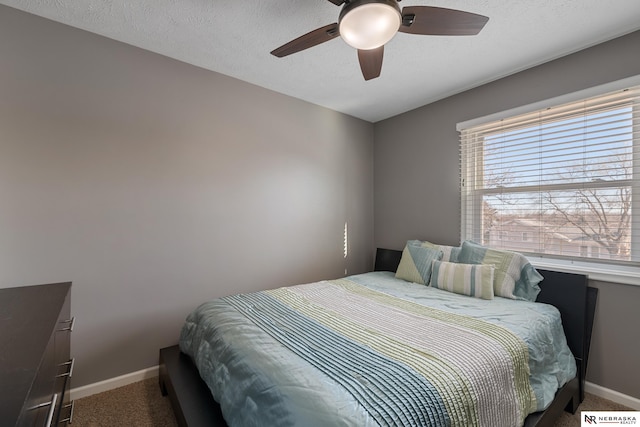 carpeted bedroom with ceiling fan and a textured ceiling