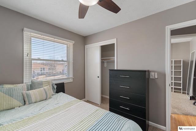 bedroom with ceiling fan, carpet flooring, a textured ceiling, and a closet