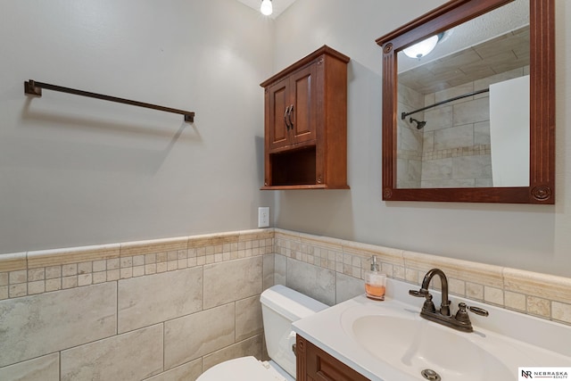 bathroom with vanity, tile walls, and toilet