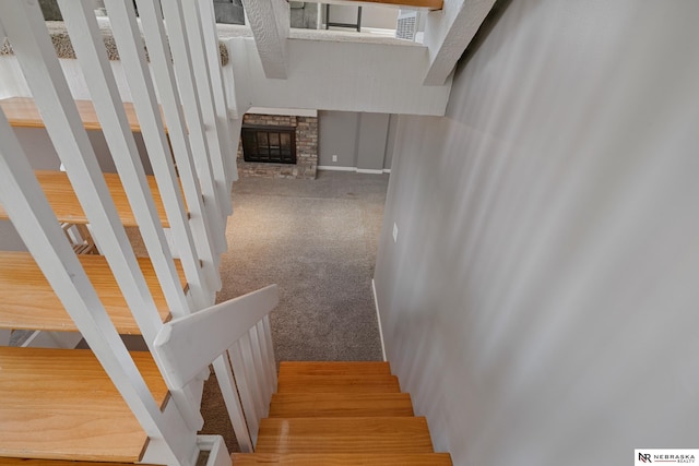 stairs with carpet floors and a fireplace