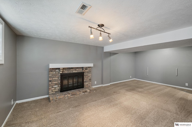 unfurnished living room with a brick fireplace, carpet floors, and a textured ceiling